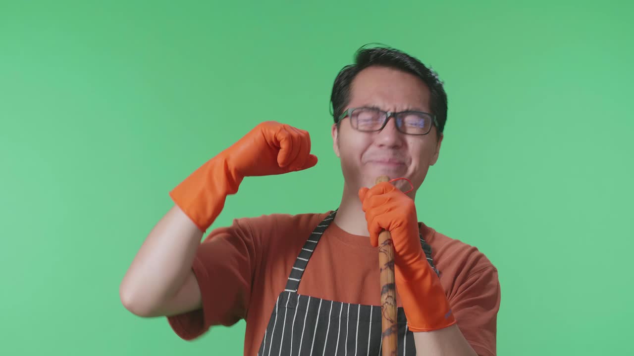 초록색 스크린 스튜디오에 서서 는 자루에 노래하는 아시안 남성 집주인의 클로즈업