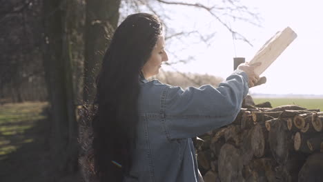 Mujer-Caucásica-Apilando-Leña-Fuera-De-Una-Casa-De-Campo