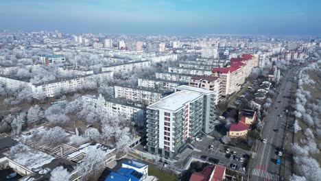 aerial view of high-rise buildings and ice-covered trees during winter in galati, romania