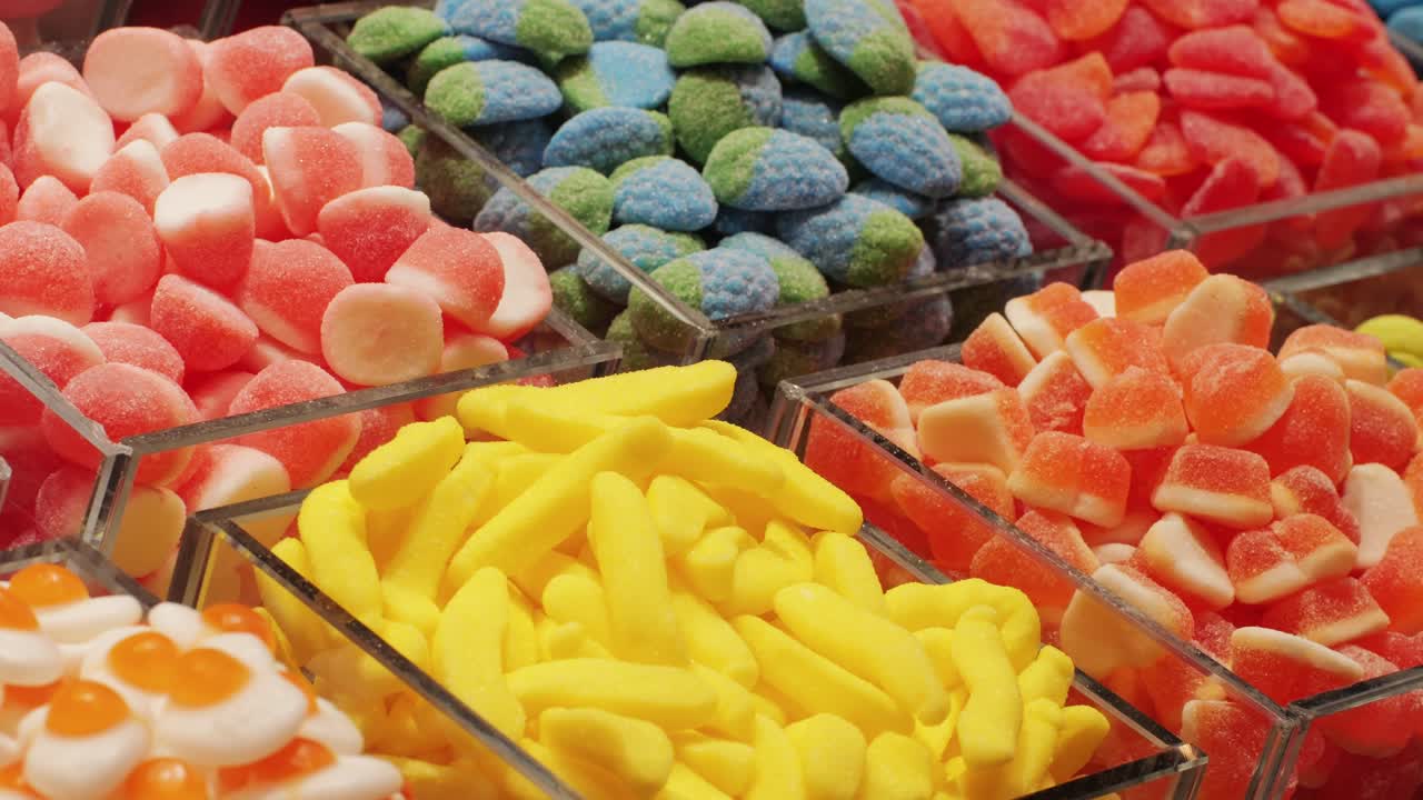 Colorful gummy candies in clear containers are captivating and tempting, appealing to the eyes and taste buds