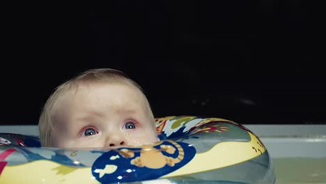 el bebé nada en el baño en un círculo inflable