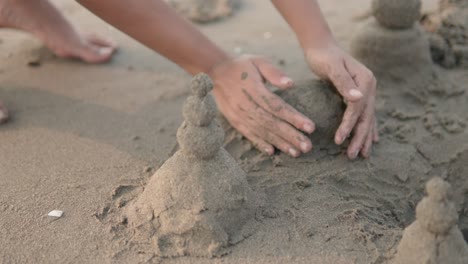 Nahaufnahme-Einer-Jungen-Frau,-Die-Während-Ihres-Sommerurlaubs-An-Einem-Wunderschönen-Strand-In-Indien-Verschiedene-Sandskulpturen-Am-Strand-Formt-Und-Mit-Ihren-Händen-Eine-Sandburg-Baut