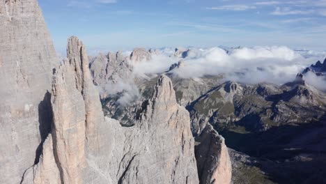 aerial orbit shot of famous tre cime di lavaredo towers during sunrise - beautiful mountain range landscape in background