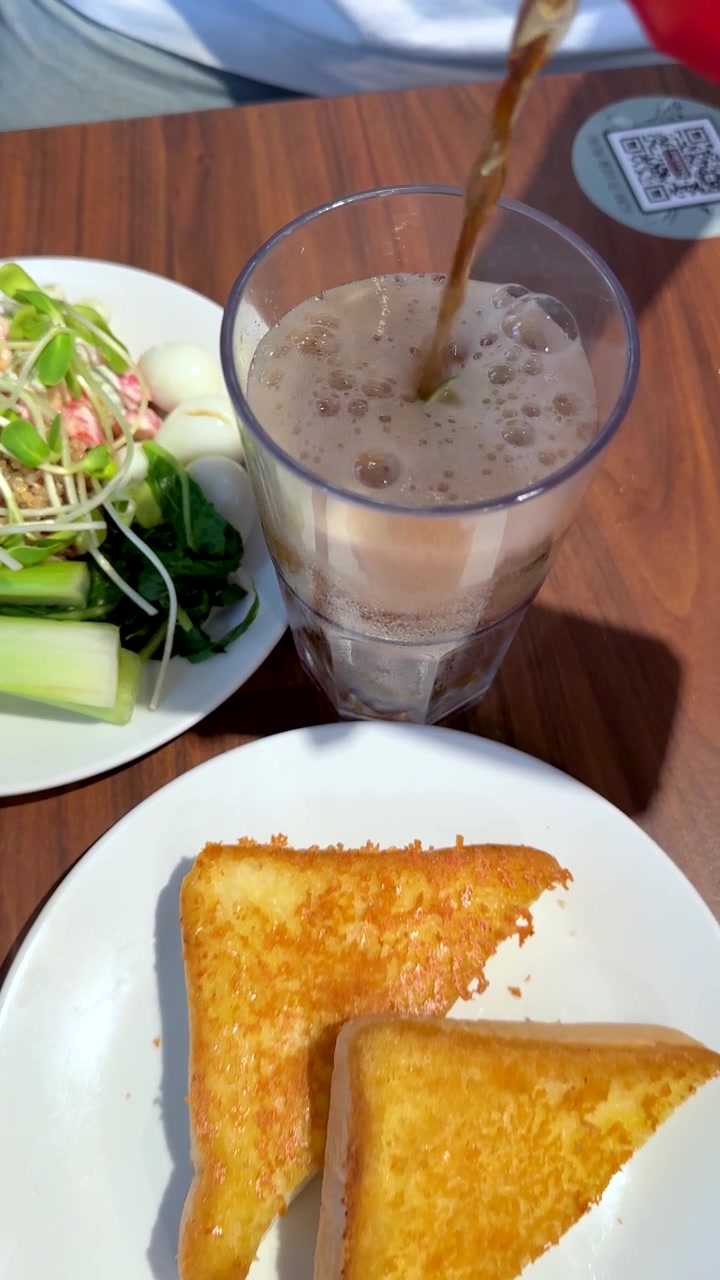 Vista superior de un plato de chuleta de cerdo con ensalada, patatas fritas, tostadas y refresco sirviéndose