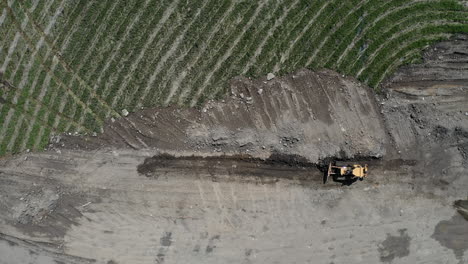 Gelber-Traktor-Bewegt-Sand-An-Den-Feldrand