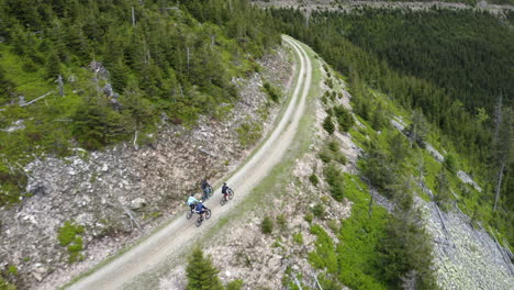 group of friends cycling on winding mountain road in moravia, drone