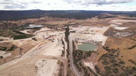 Small-open-cut-stone-quarry-aerial-circling-wide-shot,-Australia