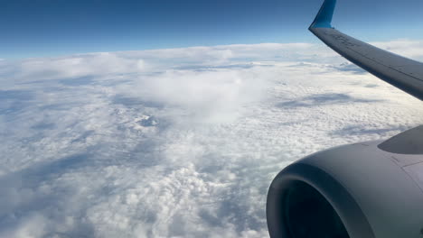 Blick-Durch-Ein-Flugzeugfenster-Auf-Den-Himmel-Und-Die-Wolken