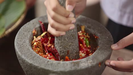 motar y chili chili machacando en morteros de piedra