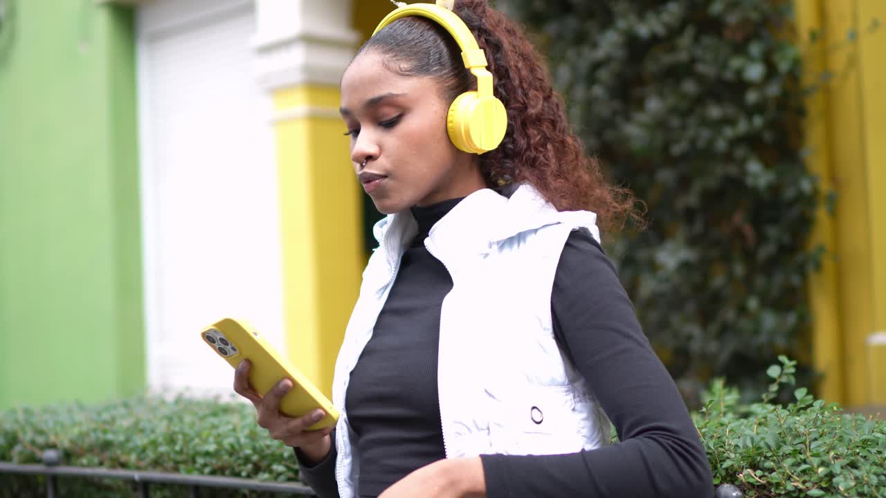 Donna con le cuffie che usa un telefono all'aperto