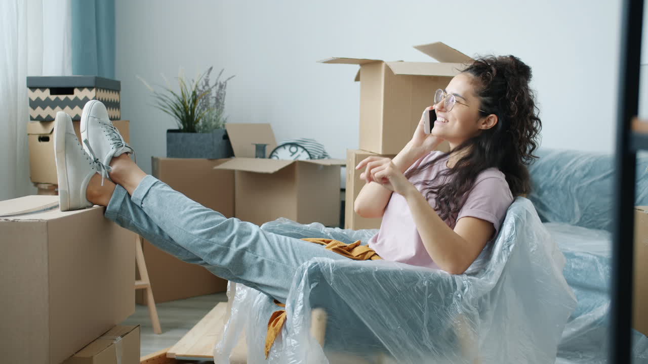 Woman relaxing with phone during a house move