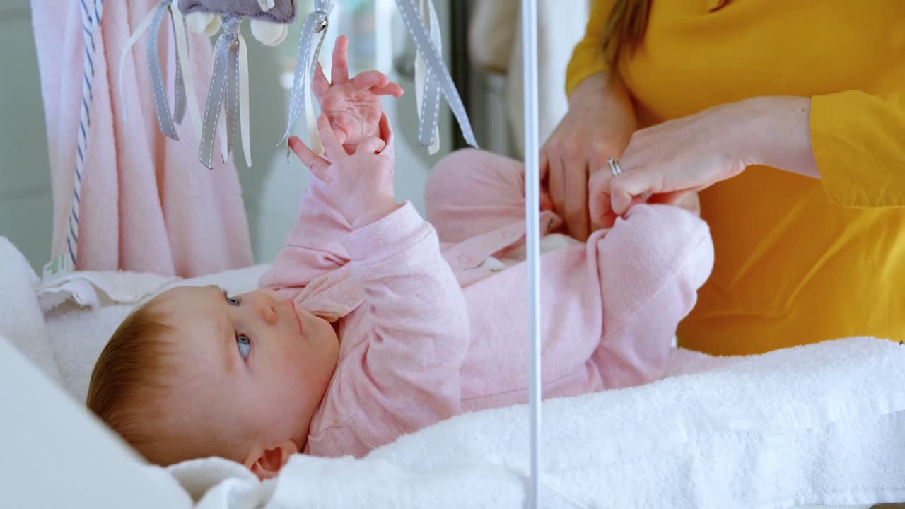 madre cambiando el pañal de su bebé 4k
