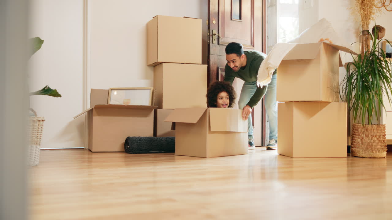 Father and Child Playfully Moving Boxes