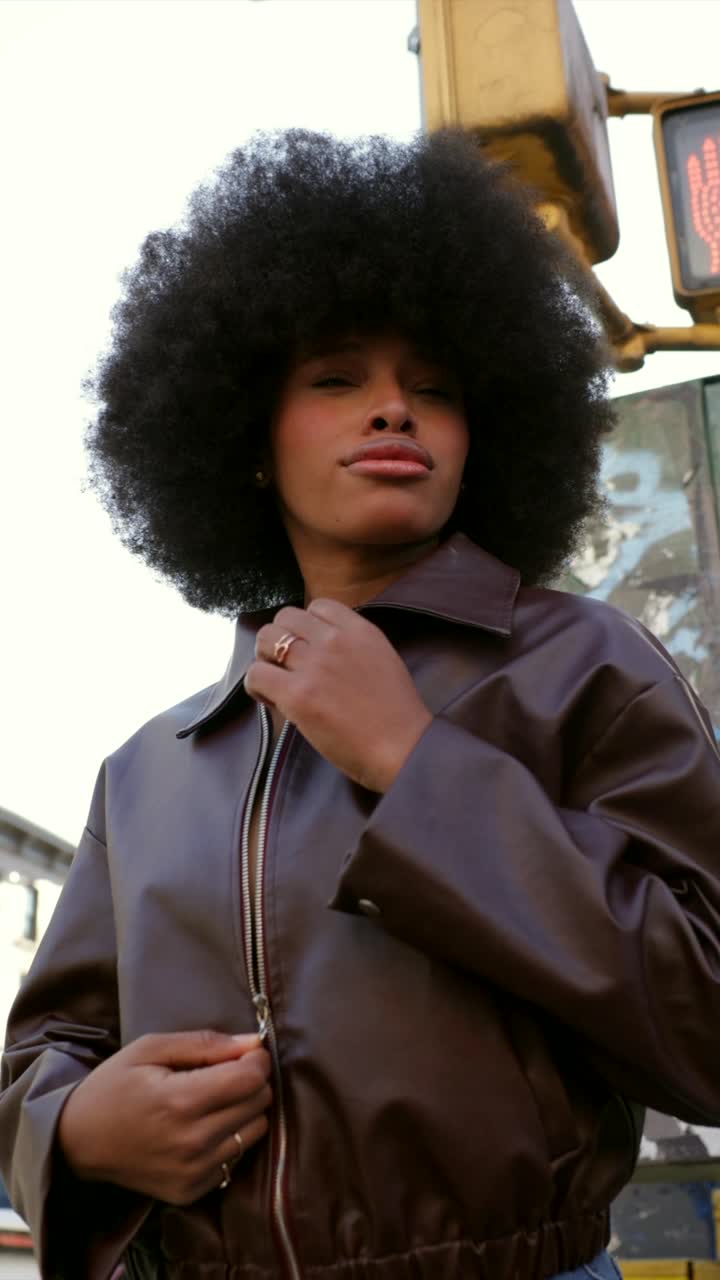 Woman with Afro and Brown Jacket in City Street