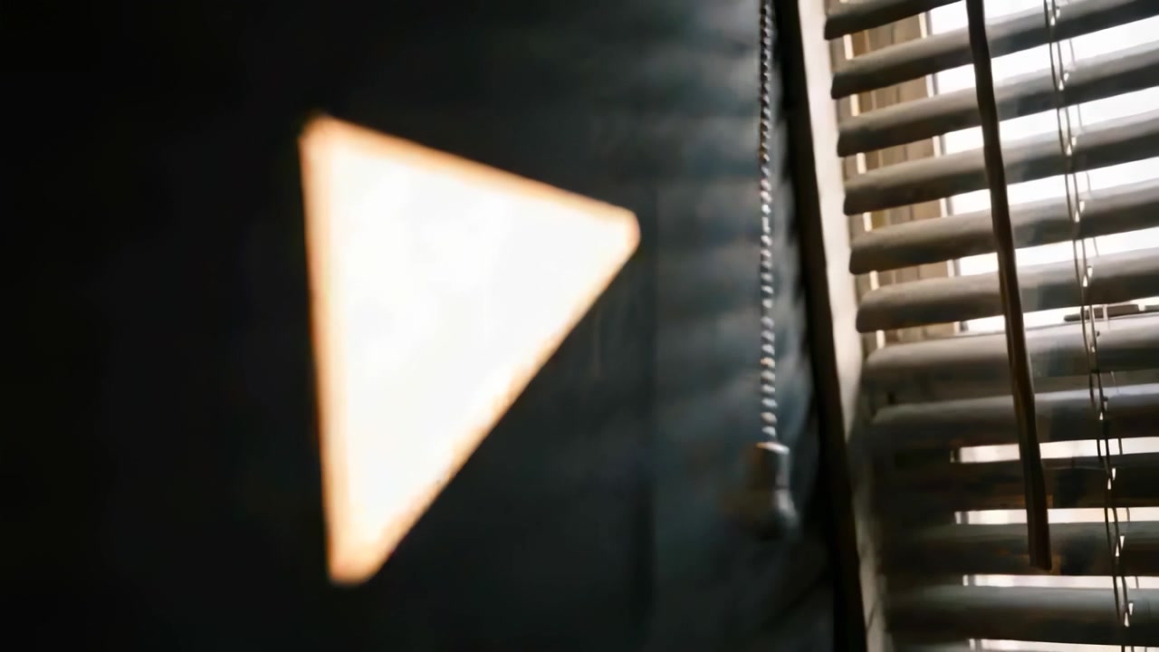 Projecting sun triangle on wall at home, sun shifting through blinds and beaded pull chain swinging
