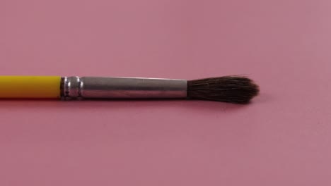 school brush on pink background, close up