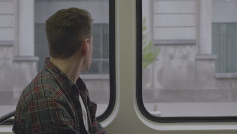 caucasian man staring out the window during a commute