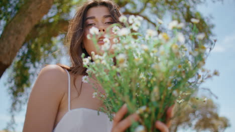 sensual girl proposing bloom at rural nature portrait. woman enjoying flowers