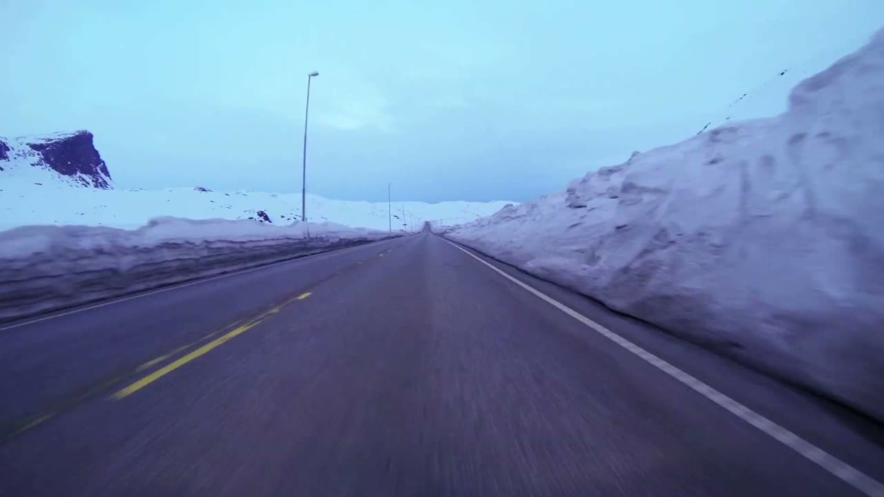 얼음과 눈이 있는 산악 도로를 따라 고속으로 이동하는 자동차의 포프 샷