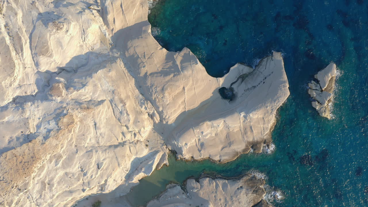 aéreo: fotografía de arriba hacia abajo de la playa de sarakiniko en la isla de milos, cícladas, grecia durante el amanecer