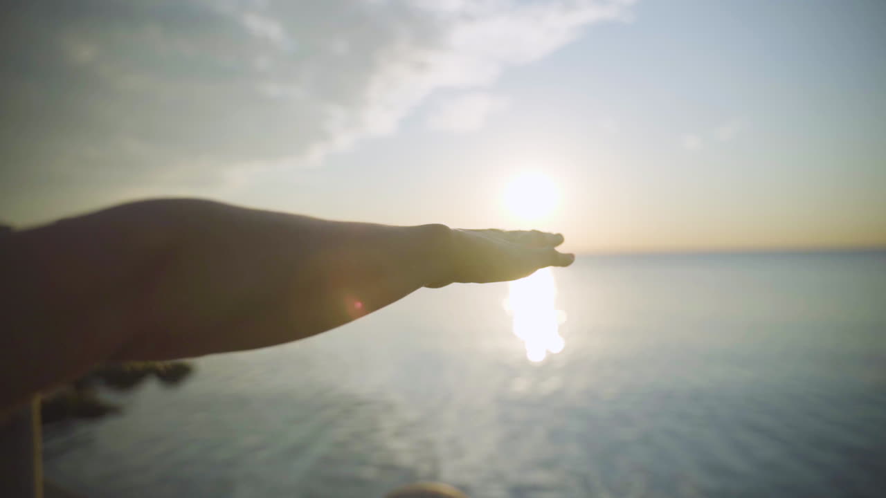 Woman's hand flipping into yoga pose at sunrise. Slow motion.