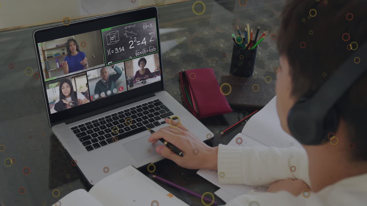 Teenage student sitting at desk using laptop in virtual classroom, viewing animated math formulas
