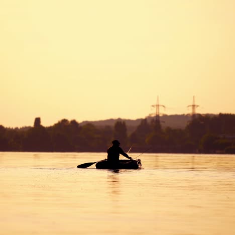 man fishing from a boat at sunset