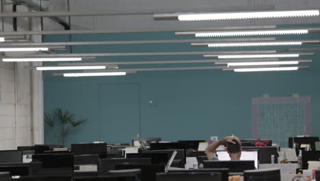 Man-scratching-his-head-while-alone-in-the-office