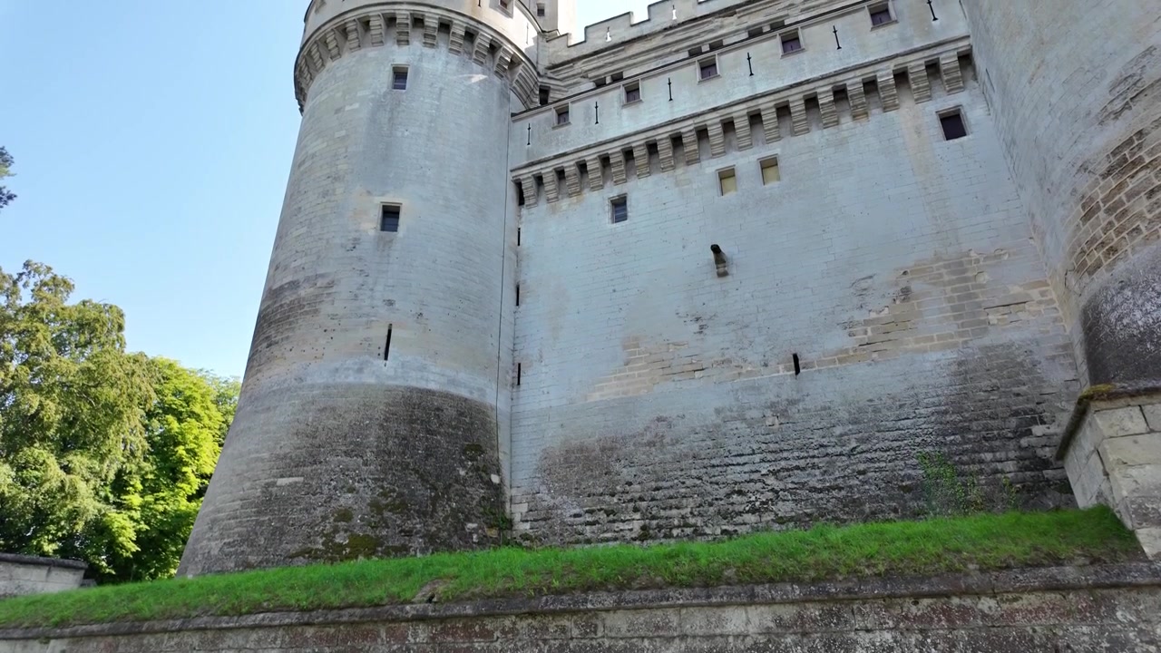 Video al rallentatore con un movimento di telecamera verso l'alto che rivela le imponenti torri e le mura fortificate del Castello di Pierrefonds negli Hauts-de-France, Francia.