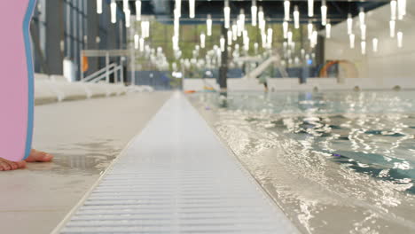 child learning to swim in an indoor pool