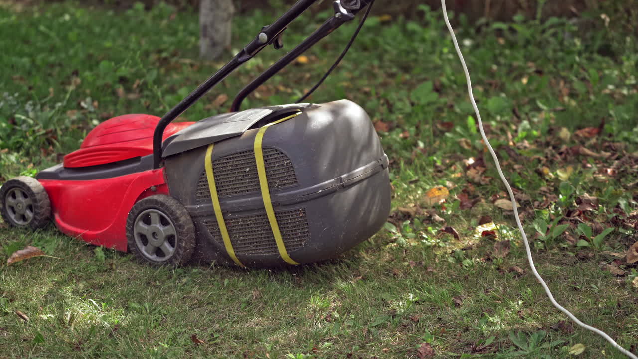 Red lawn mower cutting grass. Cutting grass with a professional lawn mower