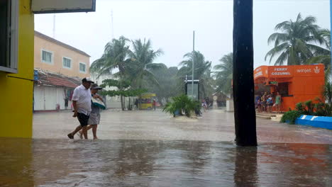 people running and walking in the rain from a patio viewpoint in mexico with ferry booth in the background