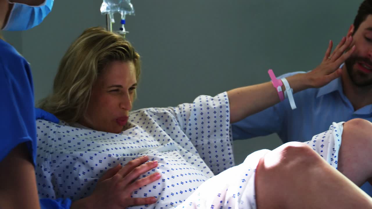 수술실 에서 임산부 의 손 을 잡고 있는 남자