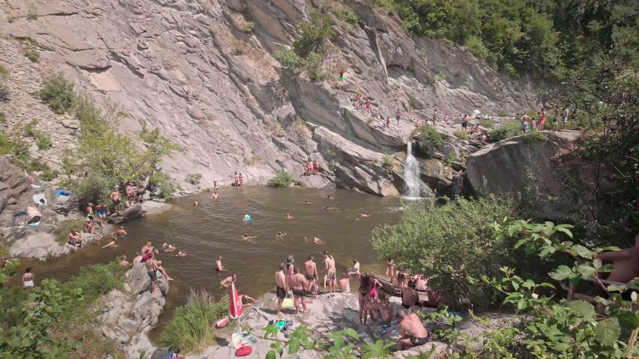 Waterfall swimming hole with people swimming