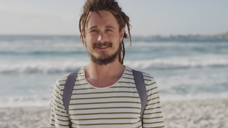 Retrato-De-Un-Joven-Lindo-Sonriendo-Feliz-En-La-Playa-Mirando-La-Cámara-Disfrutando-De-Las-Cálidas-Vacaciones-De-Verano-En-Cámara-Lenta