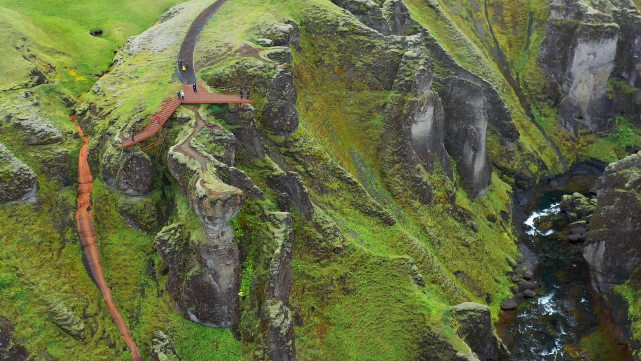 gente en el sendero y la plataforma de observación del cañón del río fjadrargljufur en islandia