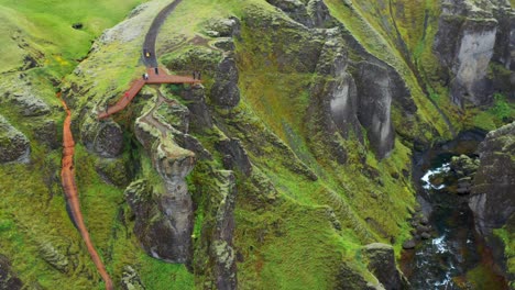 people on walking path and viewing platform of fjadrargljufur river canyon in iceland