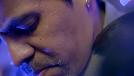 close up shot of passionate man's face putting earrings playing guitar