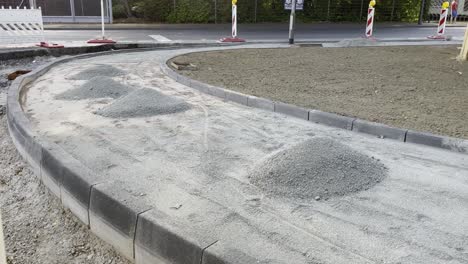 la acera de la calle se está construyendo con pequeñas pilas de piedras y la frontera del camino con el sitio de construcción