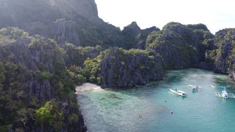 El-Retroceso-Aéreo-Revela-Una-Impresionante-Cala-Con-Canoas-Dobles-Aisladas-En-El-Nido,-Filipinas