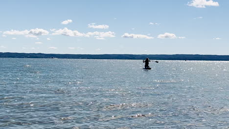 Mujer-Remando-En-El-Agua-Mientras-Se-Arrodilla-En-La-Tabla-De-Surf-En-Verano