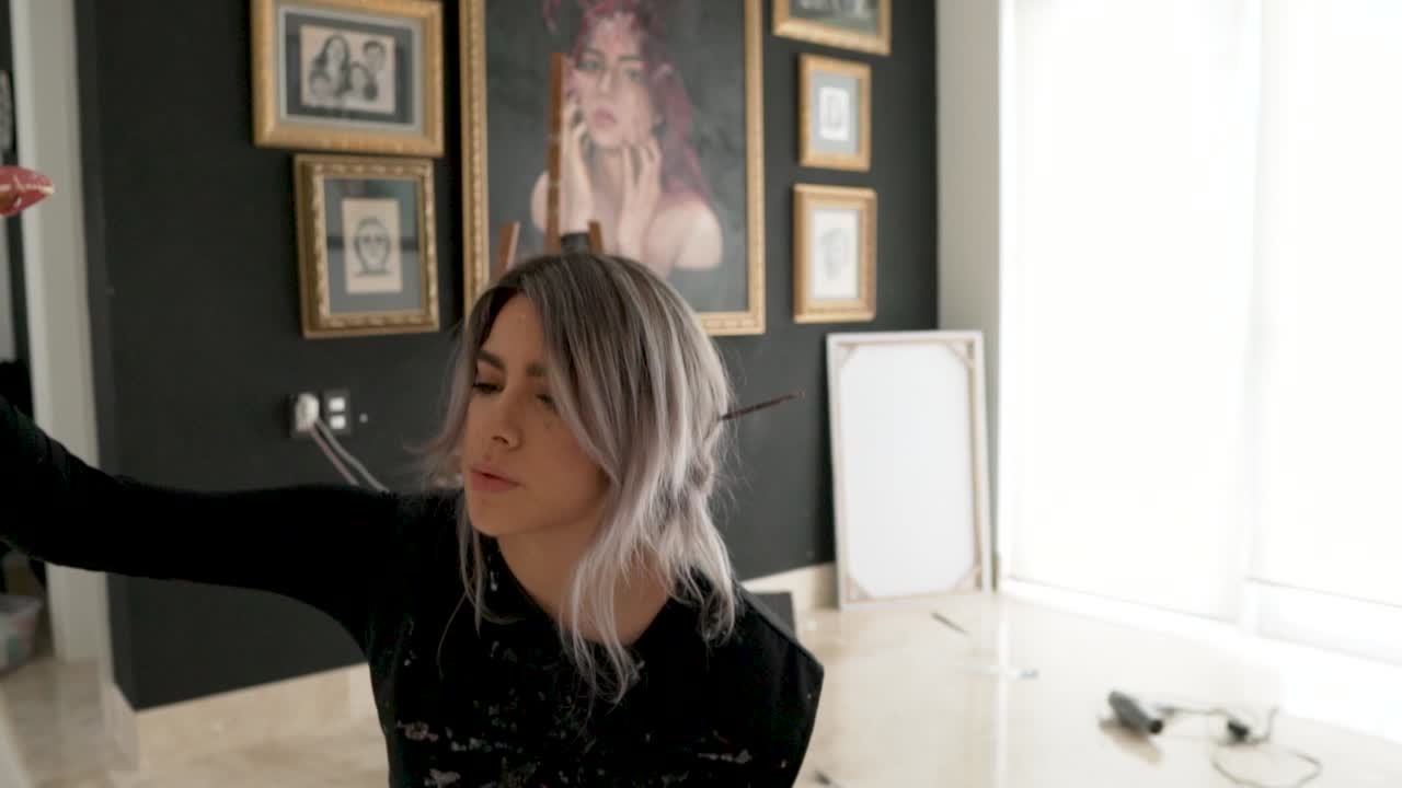 스튜디오에 큰 붓을 사용하여 캔버스에 그림을 그리는 집중된 라틴계 여성 예술가 - 중간 샷, 느린 동작