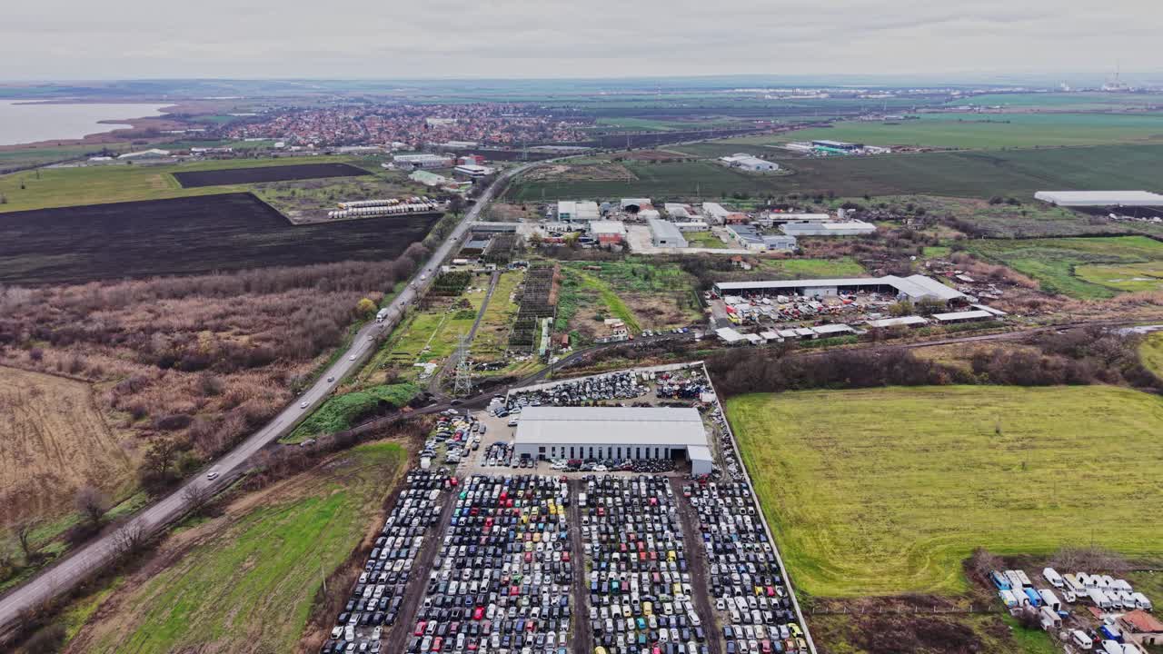 Vista dall'alto di un'area di stoccaggio veicoli e campi presso un sito industriale