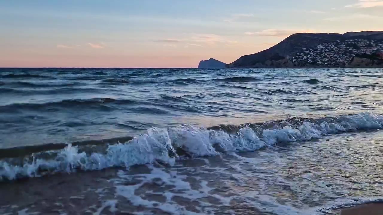 Onde e costa della spiaggia di Calpe al tramonto in una destinazione turistica spagnola