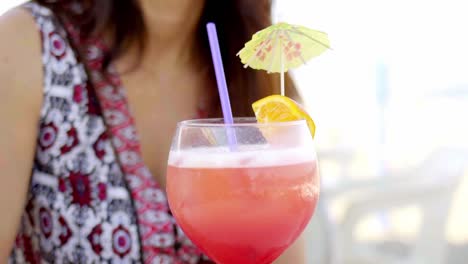 pretty woman sipping a cocktail at the beach