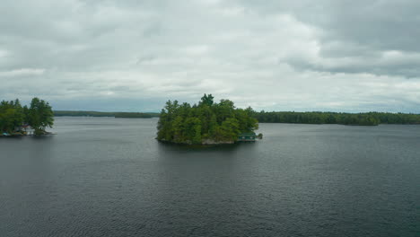 descending drone view of gem island in the middle of lake muskoka on a grey, cool day