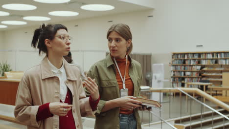mujeres caminando por la biblioteca y hablando