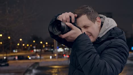 Casual-young-adult-taking-nightlife-photos-in-streets-of-Berlin-with-mirrorless-camera,-handheld-shot