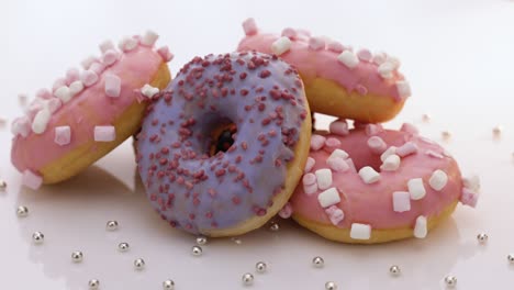 rosquillas de rotación sobre un fondo blanco. arte conceptual. rosquilla de diferentes colores. postres dulces esmaltados. comida rápida, concepto de panadería. varias rosquillas coloridas. chocolate, púrpura, rosas en 4k, uhd