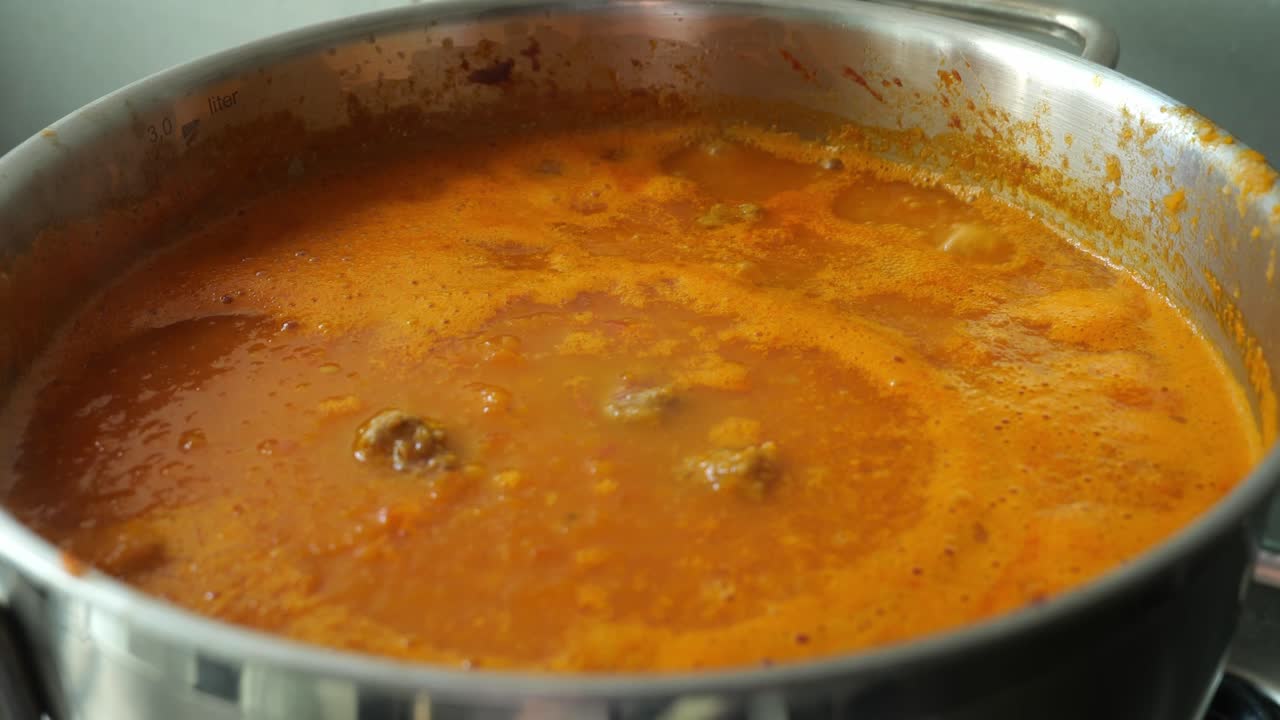 vista de cerca de la sopa de tomate hirviendo lentamente en una sartén